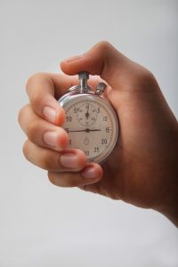 a hand holding a stop watch depicting public liability claim time limits. 