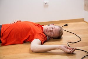 A man lying on the floor who has suffered an electric shock injury.
