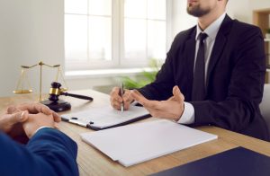 A construction site accident claim solicitor talks to a client behind a desk