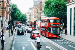 Two red buses on a busy road 