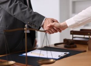 A data breach solicitor and a client shaking hands while stood by a desk