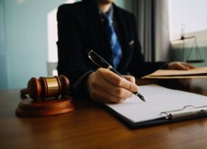 A personal injury solicitor for a psychological injury claim holding a document with one hand and writing notes with the other hand