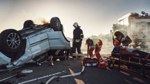 A vehicle flipped over following a car crash being attended to by emergency services. 