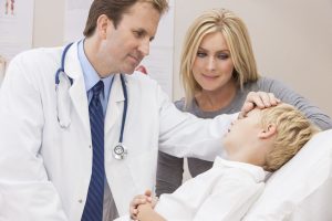 A parent and doctor comfort a child in hospital.