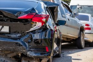 A black car crashed into the rear end of a silver car