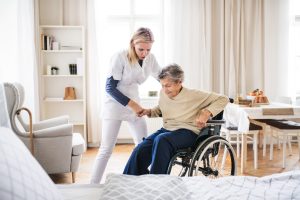 ELDERLY PERSON BEING HELPED IN WHEELCHAIR AFTER A ROAD TRAFFIC ACCIDENT CAUSED ANKLE INJURY